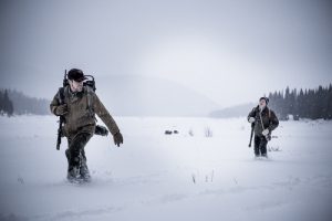 image of two hunters walking in snow from movie titled "Walking Out"