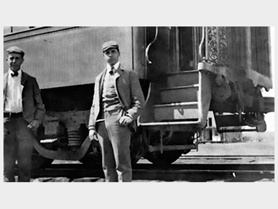 Black and white photo of people at train station