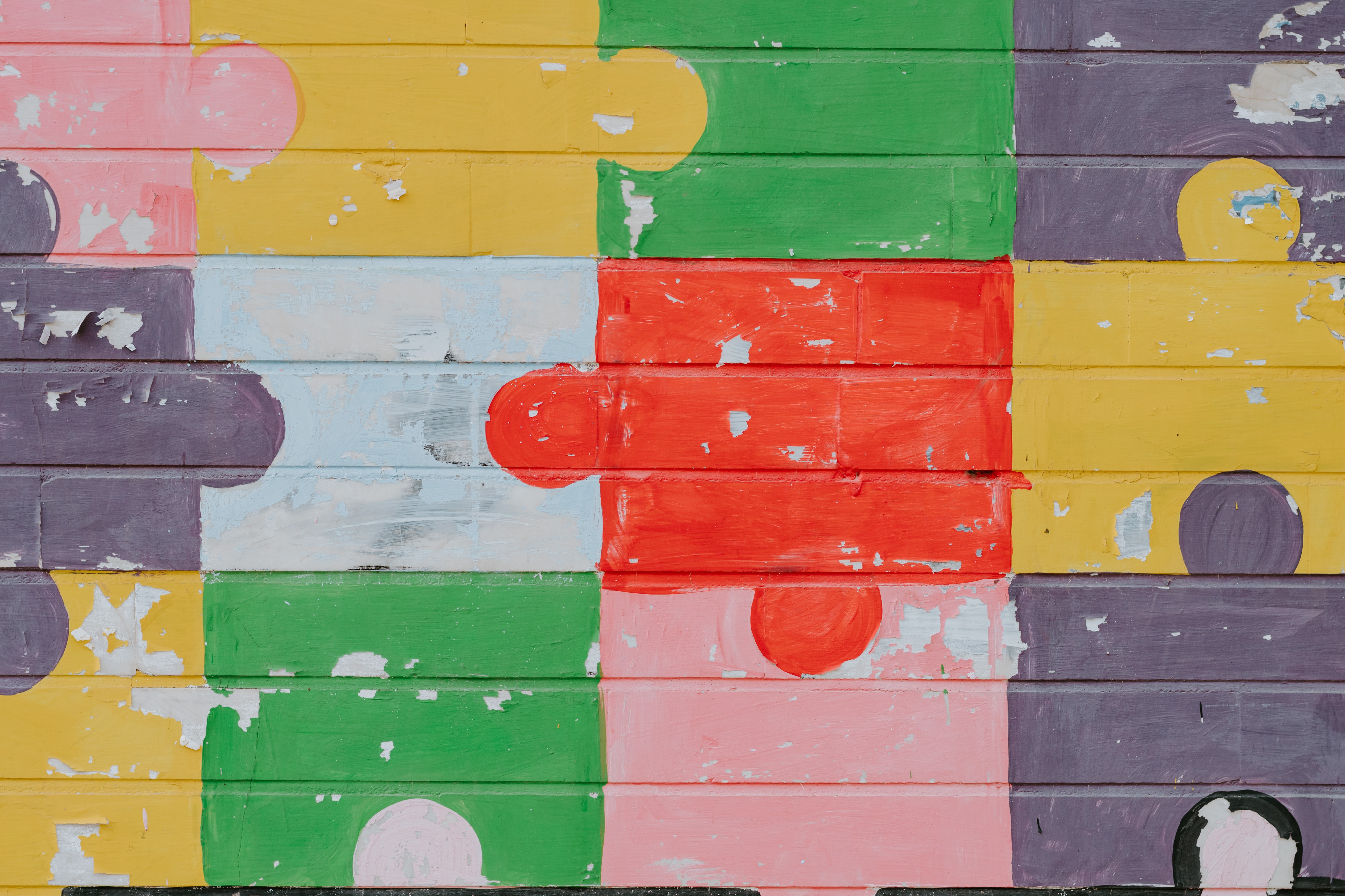 Image of colorful puzzle pieces painted on the side of a building.