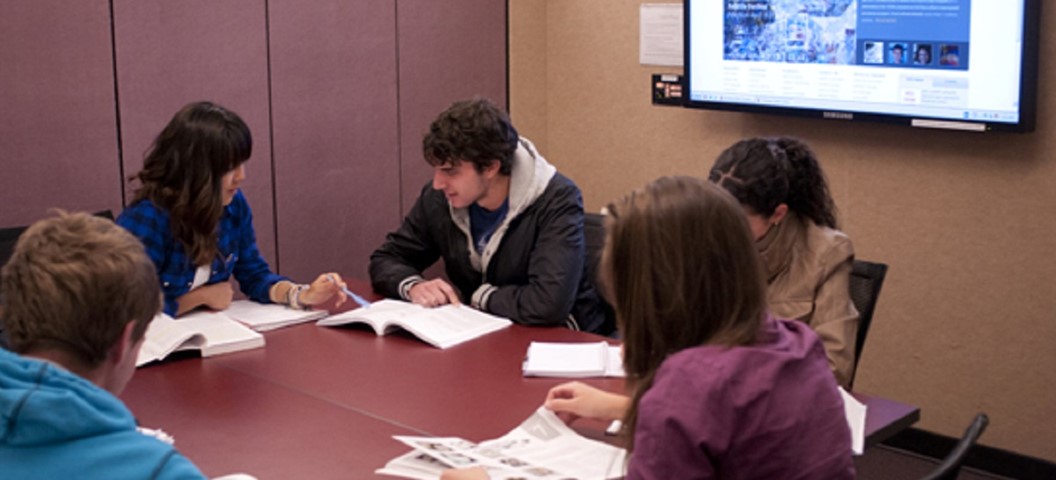 Students stuyding in a library group room.
